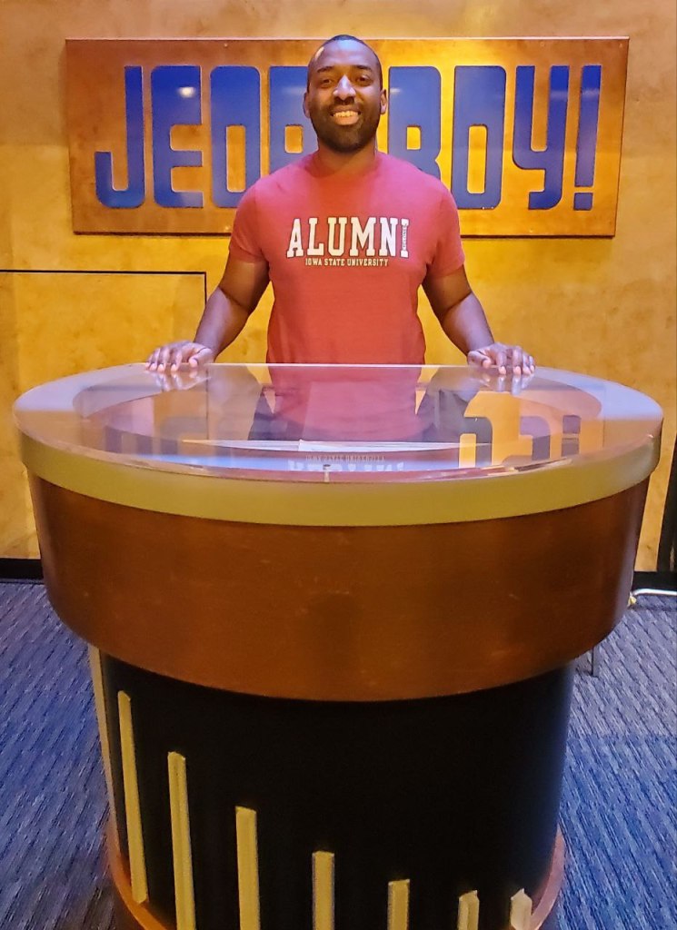 Me, posing at Alex Trebek's old podium in the Jeopardy studio gallery